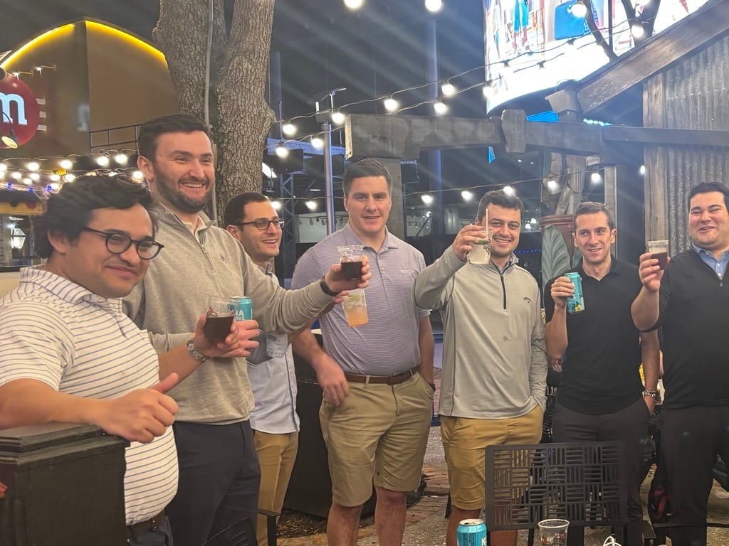 Waylin Partners team members raising drinks at an outdoor venue