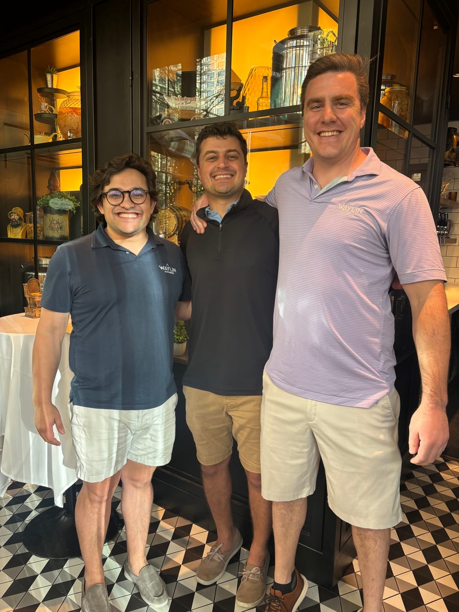 Three Waylin Partners team members at a group dinner during the Tampa offsite